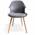 **Moderne kunststof stoel met houten poten en geperforeerde rugleuning**